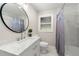 Updated bathroom featuring a marble vanity, large round mirror, and tiled shower with curtain at 2490 Turtle Ter, Grayson, GA 30017