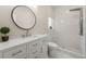 Stylish bathroom featuring a marble vanity, round mirror, and tiled shower with rainfall shower head at 2490 Turtle Ter, Grayson, GA 30017