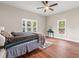 Comfortable bedroom with hardwood floors, ceiling fan, natural light, and neighborhood views at 2490 Turtle Ter, Grayson, GA 30017
