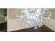 Close-up of a modern chandelier with crystal accents against a backdrop of hardwood floors at 2490 Turtle Ter, Grayson, GA 30017