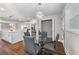 Dining area with a glass table, gray chairs, a modern chandelier, and an open concept to the kitchen at 2490 Turtle Ter, Grayson, GA 30017
