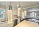 Modern pendant lights hang above a kitchen island with stainless appliances and hardwood flooring in view at 2490 Turtle Ter, Grayson, GA 30017