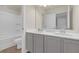 Bathroom with double sinks, grey cabinets, a bathtub, and a toilet at 571 Hancock Se Dr, Atlanta, GA 30354