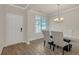 Elegant dining room with a modern chandelier, large windows, and stylish seating for six, near the front door at 571 Hancock Se Dr, Atlanta, GA 30354