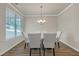 Elegant dining room with a modern chandelier, large windows, and stylish seating for six at 571 Hancock Se Dr, Atlanta, GA 30354
