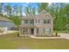 Charming two-story home with a brick facade, covered porch, manicured lawn and tree lined backdrop at 571 Hancock Se Dr, Atlanta, GA 30354