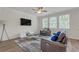 Bright living room with hardwood floors, neutral tones, a stylish rug, and a modern entertainment center at 571 Hancock Se Dr, Atlanta, GA 30354