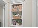 Bathroom nook with an open shelf stocked with fresh towels and decorative storage at 6900 Roswell Rd # J2, Atlanta, GA 30328