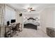 Well-lit bedroom with a large window, ceiling fan, and a cozy bed with decorative pillows at 6900 Roswell Rd # J2, Atlanta, GA 30328