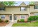 Charming townhome featuring a well-manicured lawn and inviting entrances adorned with decorative wreaths at 6900 Roswell Rd # J2, Atlanta, GA 30328