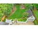 Aerial view of property showcasing lawn, garage, play area, patio, and lush landscaping at 893 E Rock Springs Ne Rd, Atlanta, GA 30306