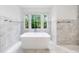 Bright bathroom featuring a soaking tub, marble tile, large windows with natural light, and sleek fixtures at 893 E Rock Springs Ne Rd, Atlanta, GA 30306