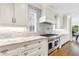 A modern white kitchen features marble countertops, stainless steel appliances, and tile backsplash at 893 E Rock Springs Ne Rd, Atlanta, GA 30306
