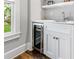 Stylish wet bar featuring a built-in wine fridge, marble countertops, custom cabinetry, and a view to the outdoor area at 893 E Rock Springs Ne Rd, Atlanta, GA 30306