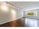 Bright living room features hardwood flooring, track lighting, and a large window at 101 Ardmore Nw Pl # 3, Atlanta, GA 30309