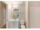 Clean bathroom features a single sink vanity, toilet, mirror, and shower at 1492 Saint George, Conyers, GA 30012