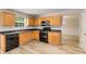 Traditional kitchen with wooden cabinets, black appliances, and light wood floors at 1492 Saint George, Conyers, GA 30012