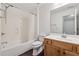 Bathroom with a shower-tub combo, neutral tile, and wooden vanity at 1680 Bluestone Dr, Cumming, GA 30041