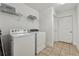 Laundry room with modern washer, dryer, tile floors, and shelving at 1680 Bluestone Dr, Cumming, GA 30041