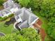 Aerial view of the home highlighting the lush greenery, manicured landscaping and large roof at 2321 Edgemere Lake Cir, Marietta, GA 30062