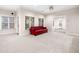 Bright basement living area with a red sofa, neutral walls, and windows with natural light at 2321 Edgemere Lake Cir, Marietta, GA 30062
