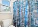 Close up on a toilet behind a shower curtain decorated with sea life motifs and a window with blinds at 2321 Edgemere Lake Cir, Marietta, GA 30062