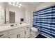 Bathroom featuring a white vanity with dark hardware, a toilet and a shower behind a striped curtain at 2321 Edgemere Lake Cir, Marietta, GA 30062
