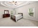 Bright bedroom with three windows, a tray ceiling, and carpeted floors at 2321 Edgemere Lake Cir, Marietta, GA 30062