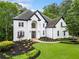 Stately white home features impeccable landscaping, a manicured lawn, and a welcoming entrance at 2321 Edgemere Lake Cir, Marietta, GA 30062