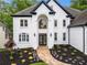 Elegant two-story home with a white facade, dark accents, and a stone pathway leading to the entrance at 2321 Edgemere Lake Cir, Marietta, GA 30062