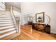 Elegant foyer featuring hardwood floors, a staircase, and decorative accents on a vintage sideboard at 2321 Edgemere Lake Cir, Marietta, GA 30062