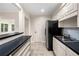 Kitchen featuring white cabinets, stainless steel sink, and black refrigerator at 2321 Edgemere Lake Cir, Marietta, GA 30062