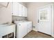 Bright laundry room with a utility sink, washer, dryer, and convenient access to the exterior at 2321 Edgemere Lake Cir, Marietta, GA 30062