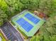 Aerial shot showcasing two well-maintained tennis courts surrounded by lush greenery and parking area at 2321 Edgemere Lake Cir, Marietta, GA 30062