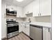 Well-lit kitchen featuring modern stainless steel appliances, white cabinets, and light countertops at 2965 Pharr Court South Nw # 718, Atlanta, GA 30305