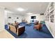 Inviting living room with a blue carpet, comfortable seating, and built-in shelving for displaying books and decorative items at 2965 Pharr Court South Nw # 718, Atlanta, GA 30305