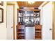 Home bar setup with custom wood cabinets, wine rack, mini fridge, and ample storage space at 320 Riverbend Dr, Mcdonough, GA 30252