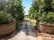 Gated driveway leading up to a luxurious estate surrounded by trees at 320 Riverbend Dr, Mcdonough, GA 30252