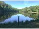 Tranquil pond surrounded by lush greenery, reflecting the sky at 320 Riverbend Dr, Mcdonough, GA 30252