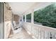 Covered porch with white rocking chairs provides a serene outdoor space with views of lush greenery at 320 Riverbend Dr, Mcdonough, GA 30252