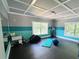 Workout room with blue accents, black floor matts, yoga mat, and multiple windows at 320 Riverbend Dr, Mcdonough, GA 30252