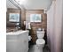Bathroom featuring wood paneled wall, decorative artwork, toilet, and white vanity at 64 Edwin Pl Nw, Atlanta, GA 30318