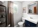 Bathroom features a blue vanity cabinet with a white sink, toilet, and a shower curtain at 64 Edwin Pl Nw, Atlanta, GA 30318