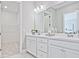 Bright bathroom with dual sinks, quartz counters, and a walk-in closet with wire shelving at 7220 Winderlea Ln, Cumming, GA 30040