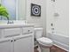 Well-lit bathroom featuring white cabinetry, modern fixtures, and a shower-tub combo at 7220 Winderlea Ln, Cumming, GA 30040