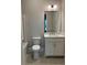Bright bathroom featuring a white vanity, large mirror, and tiled floors at 7220 Winderlea Ln, Cumming, GA 30040