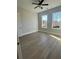 Bright bedroom with hardwood floors, a ceiling fan, and multiple windows offering natural light at 7220 Winderlea Ln, Cumming, GA 30040