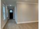 Bright entryway with hardwood floors, white trim, and a black front door at 7220 Winderlea Ln, Cumming, GA 30040