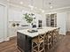 Stylish kitchen island with seating, stainless steel appliances, and bright lighting at 7220 Winderlea Ln, Cumming, GA 30040