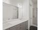 A full bathroom featuring double sinks with a white countertop and walk-in shower at 130 Forrest Aly, Roswell, GA 30075